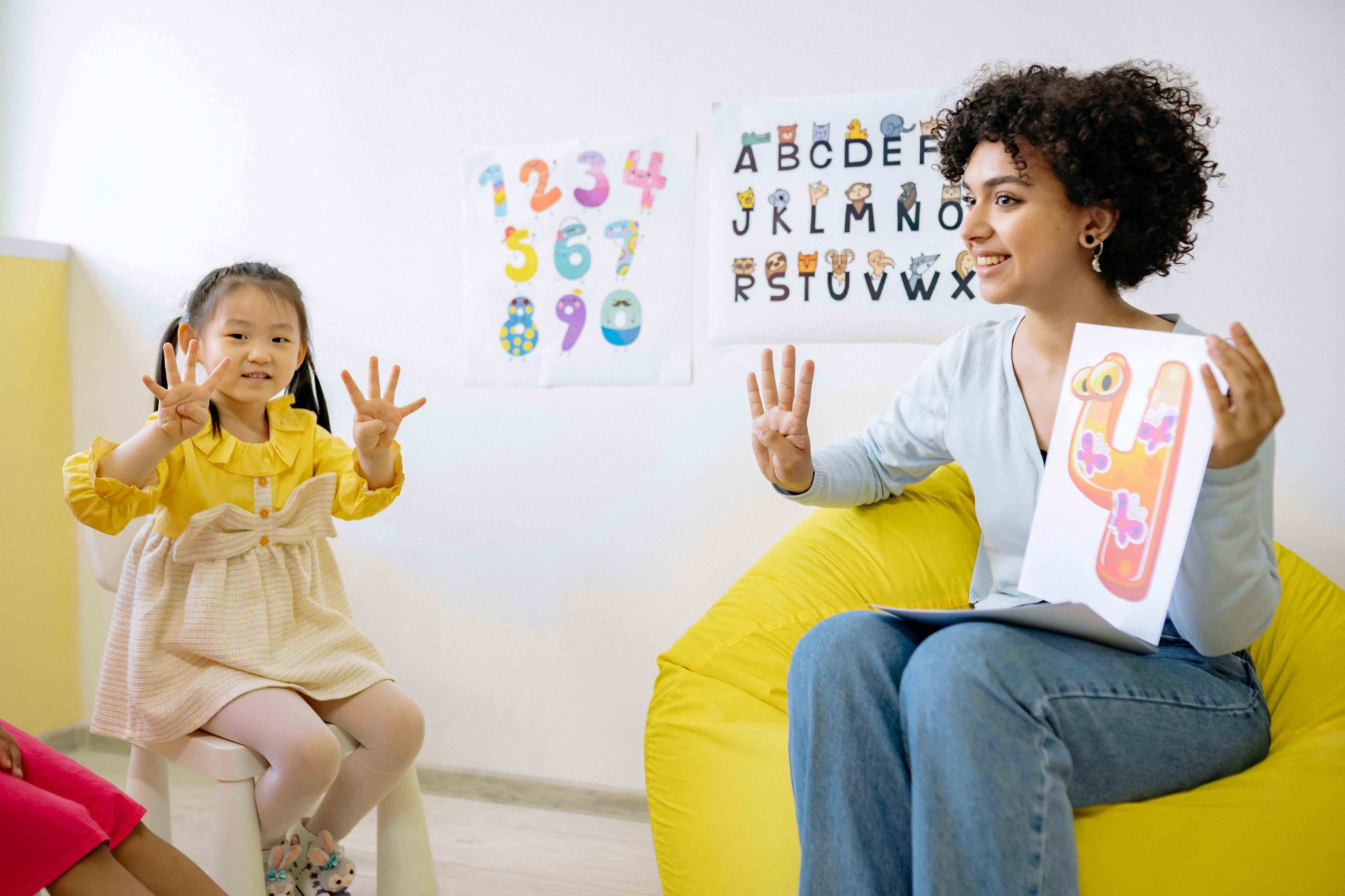 Pre-school teacher practices the number 4 with student